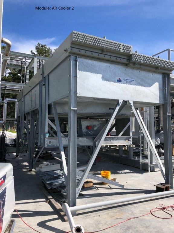 A second air-cooler module on a steel support frame, photographed from below in a fabrication yard.