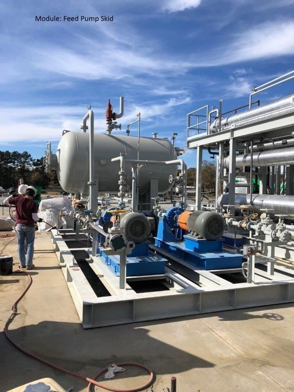 A feed pump skid with blue pumps and associated vessels and pipework on a steel base frame.
