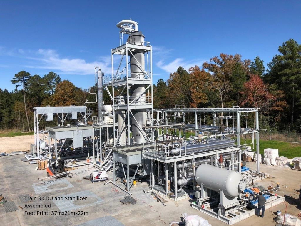 A complete modular refinery train — crude distillation unit and stabiliser — assembled and standing in a fabrication yard under blue sky, with a caption in the image reading Train 3 CDU and Stabilizer, Assembled, Foot Print 37m x 21m x 22m.