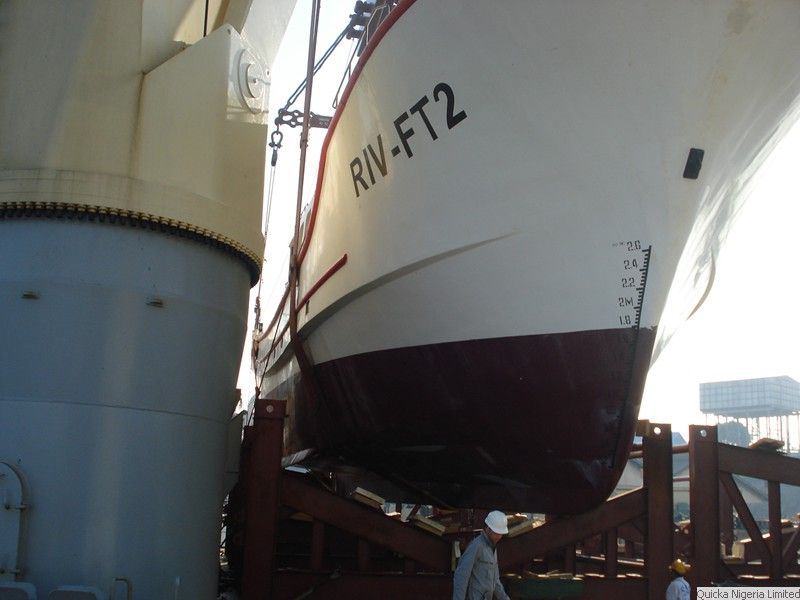 The white and dark red hull of a vessel marked RIV-FT2 sitting on a steel cradle, with draught markings visible.
